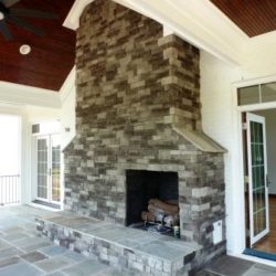 Screened in porch with large stone fireplace